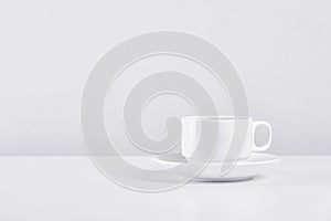 White cup of coffee on white tabale ,on white cement background