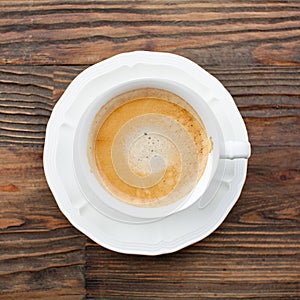 White cup of coffee whith fragrant foam on  broun wooden background