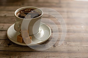 White Cup of coffee on wood natural background cane sugar pieces on plat