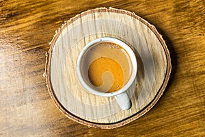 White cup of coffee on a wooden stand