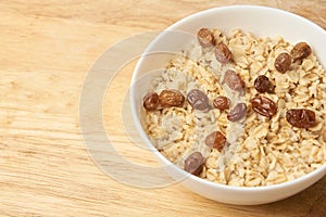 White cup. Delicious healthy breakfast. Oatmeal with raisins