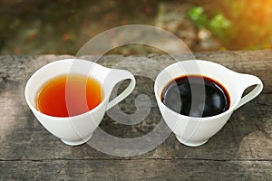 White cup of earl grey tea and coffee on wooden background