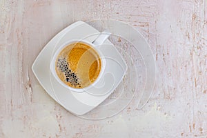 White cup of espresso on a light rustic background