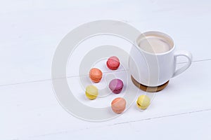 White Cup of fragrant cappuccino with macaroni cakes on white background