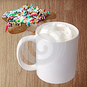 White cup with frothed milk and cookie