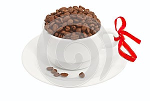 White cup full of coffee beans with red ribbon