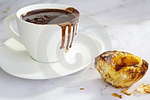 White cup with hot chocolate and portuguese custard tart called pastel de nata photo