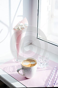 The White cup of hot coffee against window with morning light. Morning routine minimal concept