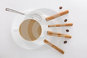 White cup of hot coffee and Cinnamon sticks