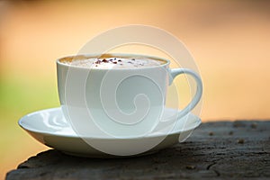 White cup of hot coffee on natural background