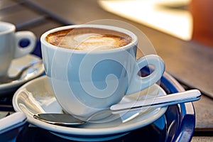 White cup with italian coffee capuccino made from fresh roasted coffee beans and hot milk