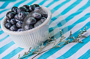 A Cup Of Juicy Blueberries At A Bright Blue Stripy Background