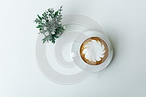 White cup of Latte art coffee with Flower Pot on white table