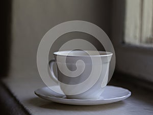 White cup is located on a windowsill