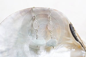 White cup with many stone mineral earrings on white background