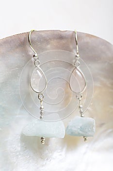 White cup with many stone mineral earrings on white background