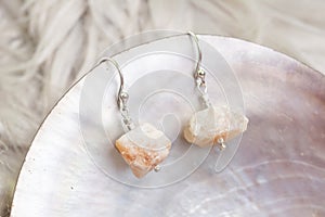White cup with many stone mineral earrings on white background