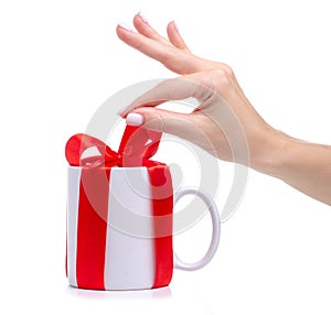 White cup mug with red ribbon bow gift in hand