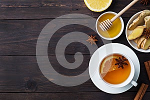 White Cup with natural herbal tea ginger lemon and honey cinnamon. Energy vitamin drink is used for colds.Dark wooden background