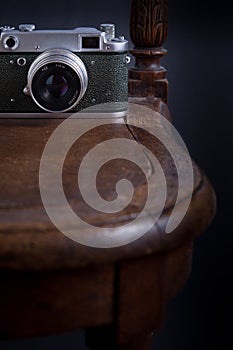 White cup on the old armchair with scarf  in dark key close up