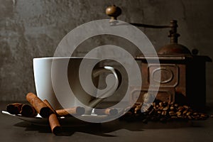 White cup and old coffee grinder