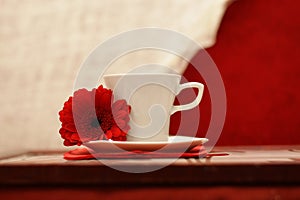 White cup, a red flower, luxurious background