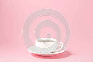 white cup with a saucer on a pink background/white cup with a saucer on a pink background, selective focus