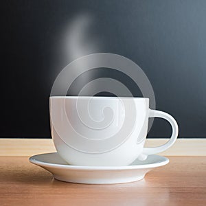 White cup and saucer on wood table