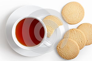 White cup of tea and saucer with shortbread biscuits from above.