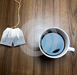 white cup of tea and tea bag on a wooden table ,isolated