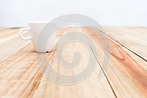 White cup on wooden table and cement wall background,Soft focus