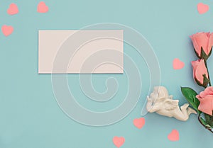 White Cupid, envelope, pink rose on blue background. Valentine`s Day greeting or invitation card. February, birthday, wedding,