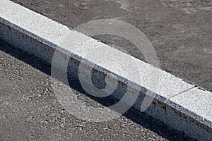 White curb and asphalt road photo