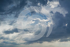 White curly clouds in a blue sky with dark clouds. Sky background.