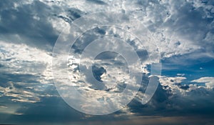 White curly clouds in a blue sky with dark clouds. Sky background.