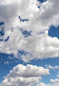 White curly clouds in the blue sky, vertical format