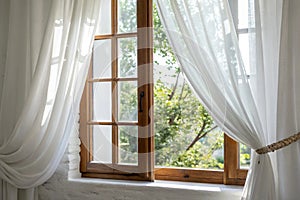 White curtains in a bright room with a window