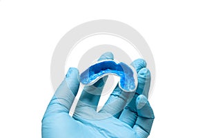 A white custom mouthguard in hand