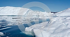 White and dazzling blue icebergs floating in the Ilulissat Icefjord in Greenland