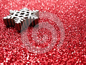 White decorative snowflake on red shiny background with copy space. Christmas abstract background. Abstract bokeh lights. Shiny