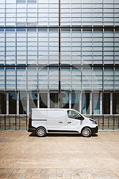 White delivery service wan parked in front of modern office indu