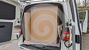 A white delivery van neatly packed with large flat boxes