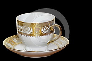 White designer cup and saucer isolated on black