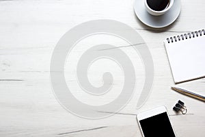 White desk office with laptop, smartphone and other work supplies with cup of coffee. Top view with copy space for input