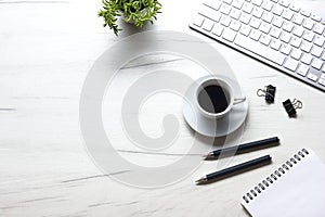 White desk office with laptop, smartphone and other work supplies with cup of coffee. Top view with copy space for input