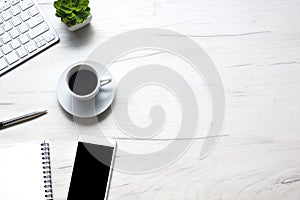 White desk office with laptop, smartphone and other work supplies with cup of coffee. Top view with copy space for input