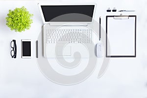 White desk office with laptop, smartphone and other work supplies with cup of coffee. Top view with copy space for input the text