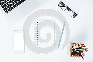 White desk with smartphone and notepad