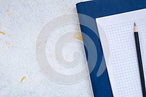 White desktop, green notebook lies on the table, pensil, with copy space, for advertisement