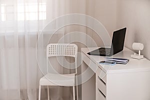 White desktop with laptop for remote work or study. Office computer workplace in home interior